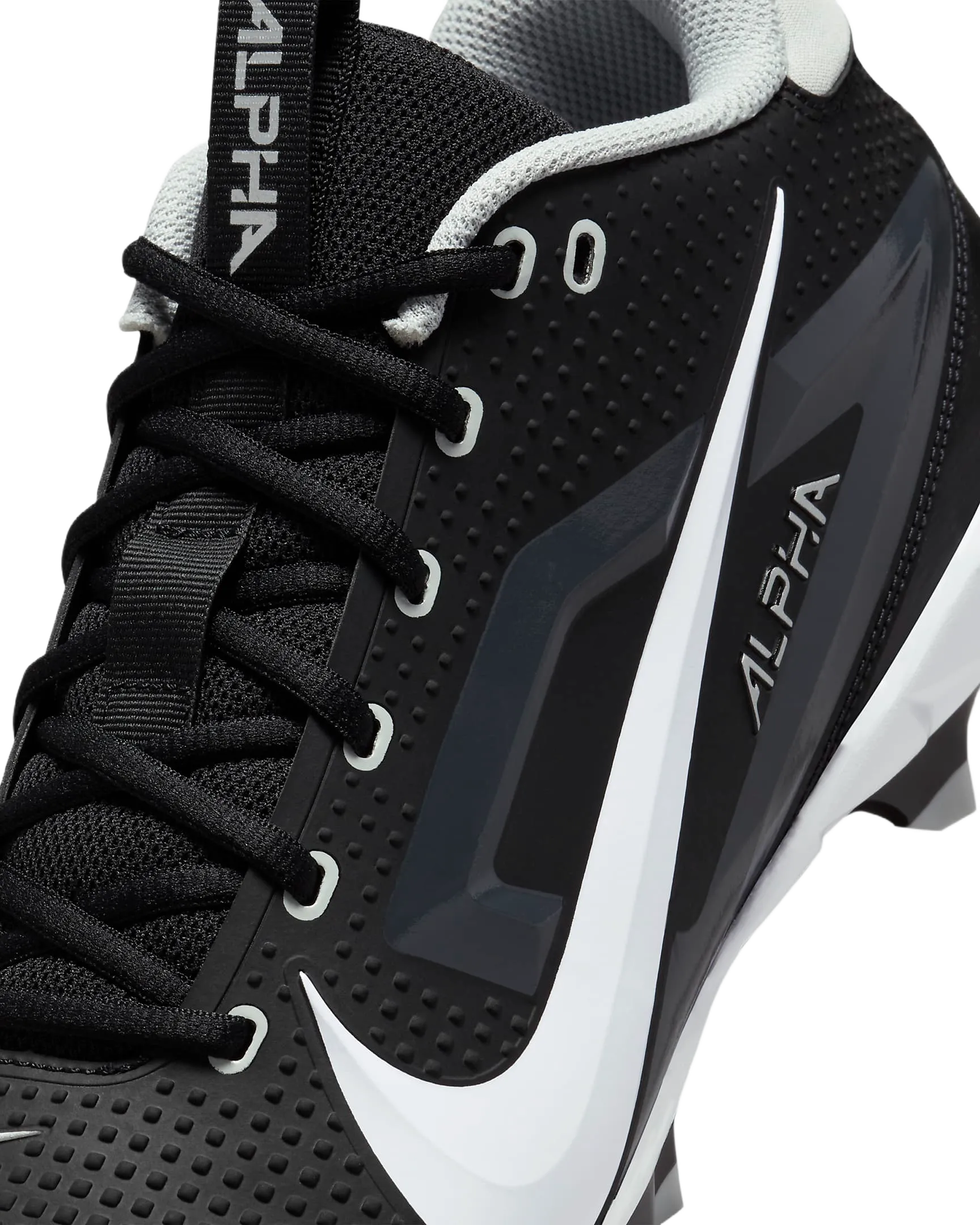 Close-up of black Nike Alpha Menace Varsity 4 football cleat with white swoosh and laces, designed for natural movement and cushioning.