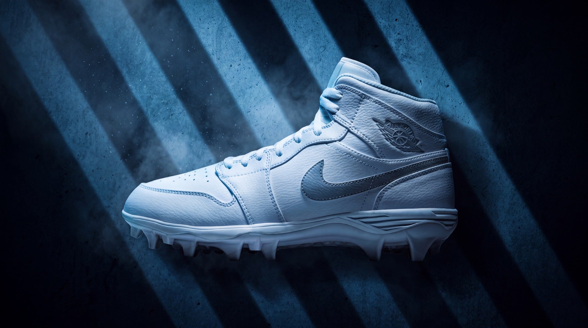 White Jordan football cleat with Jumpman logo in cold blue striped studio light