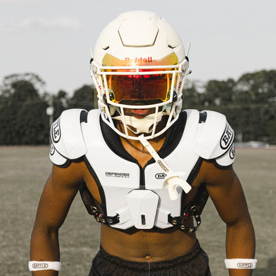 Athlete wearing white Battle Defender Adult shoulder pads on the field