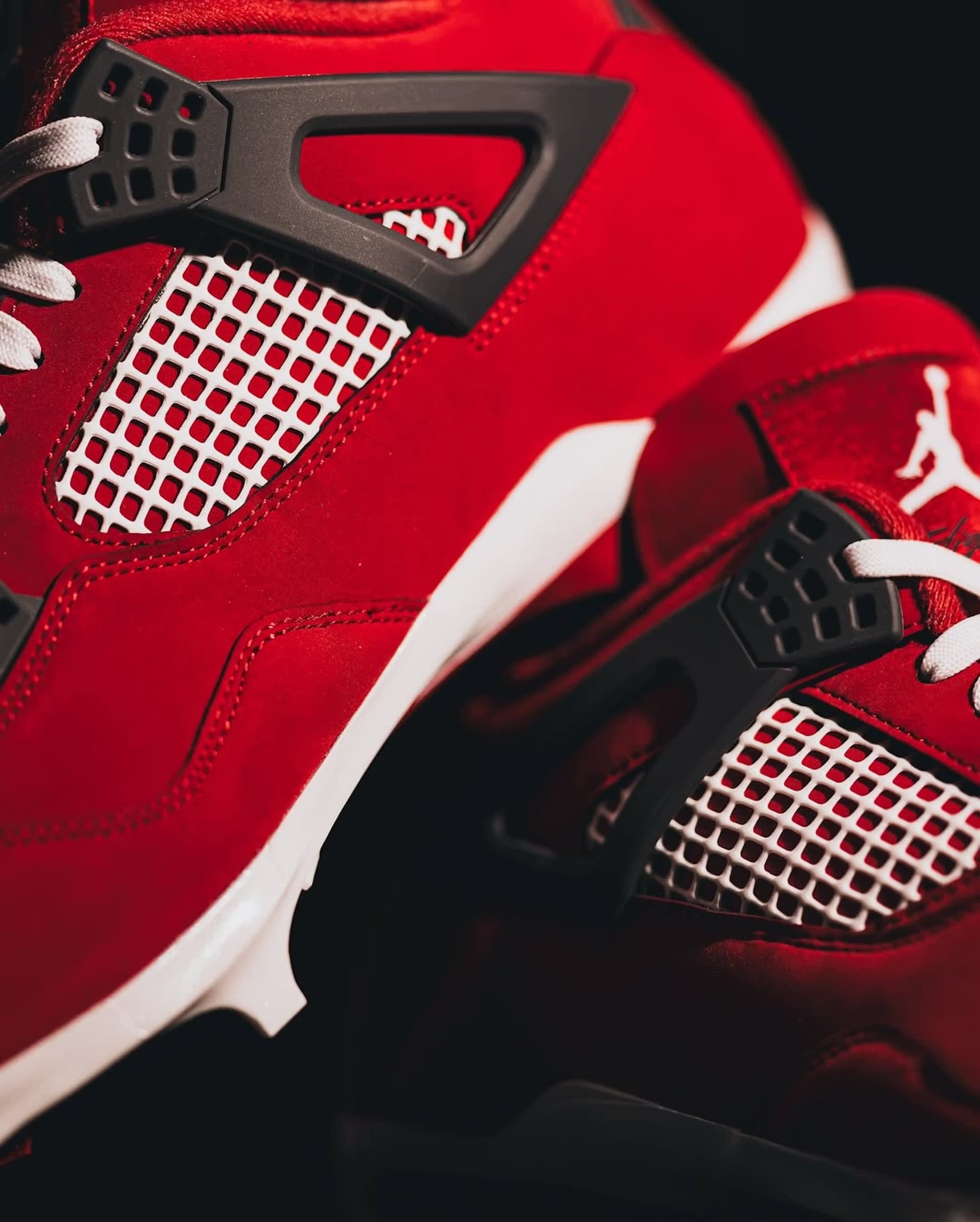 Close-up of a red sneaker with black and white accents on a dark background